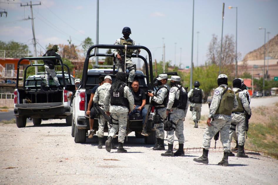 Mexican National Guard members arrest a migrant who tried crossing the Río Bravo in Ciudad Juárez,