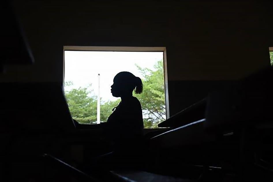 A young woman stands by a window at a secondary school in Dakar. 