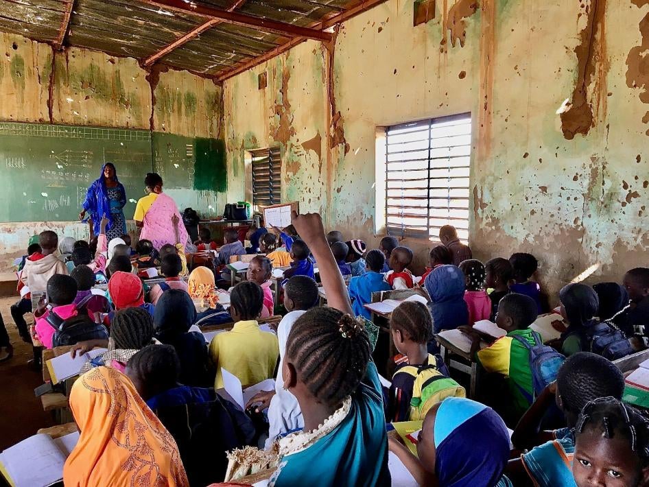 Une élève lève la main pour répondre à une question de son institutrice dans une salle de classe bondée d’une école primaire publique à Kaya, une ville de la région burkinabè du Centre-Nord qui accueille des dizaines de milliers de personnes déplacées. En janvier 2020, l’établissement comptait 748 élèves, dont 113 déplacés. « Chaque jour, des élèves déplacés viennent... Nous ne refusons pas d’inscriptions, mais s’il n’y a pas de places, ils ne peuvent pas commencer&nbsp;», a déploré le directeur de l’école. 
