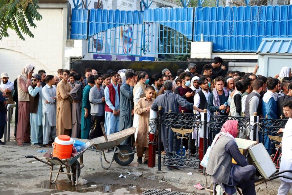 Afghans wait for hours to try to withdraw money from a bank in Kabul, Afghanistan, August 30, 2021. 