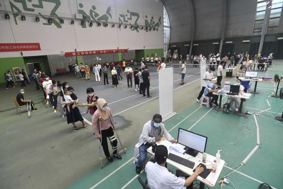 Migrant workers line up for the Covid-19 vaccine at a temporary inoculation site in Wuhan in central China's Hubei province, August 23, 2021. 
