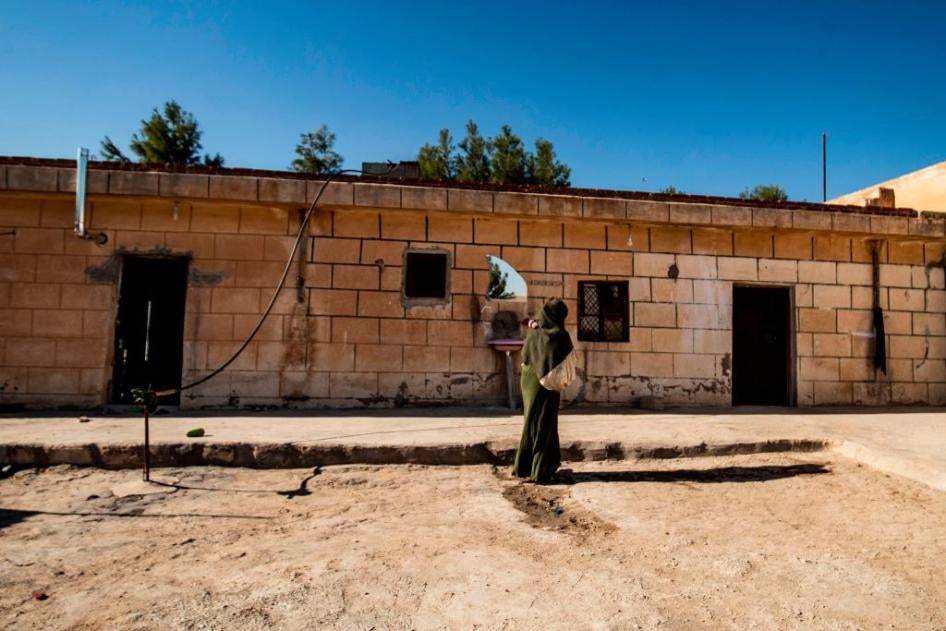 A 22-year-old Iraqi Yezidi woman carries her 2-year-old son at her home in al-Hasakeh, northeastern Syria, on November 23, 2020.