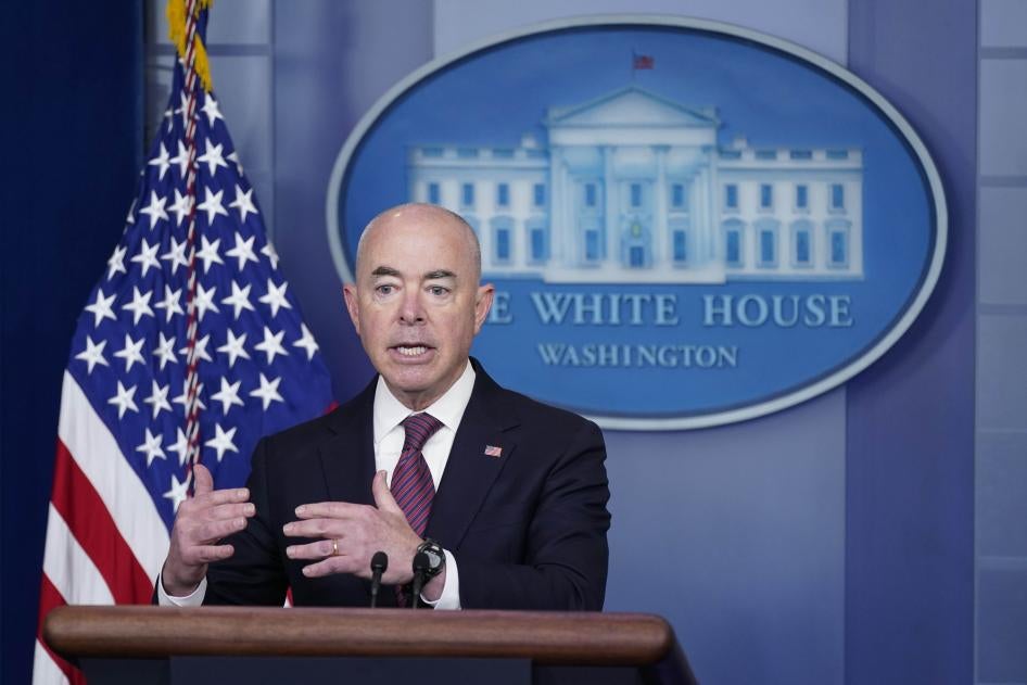 A man stands in front of a podium with the White House emblem behind him