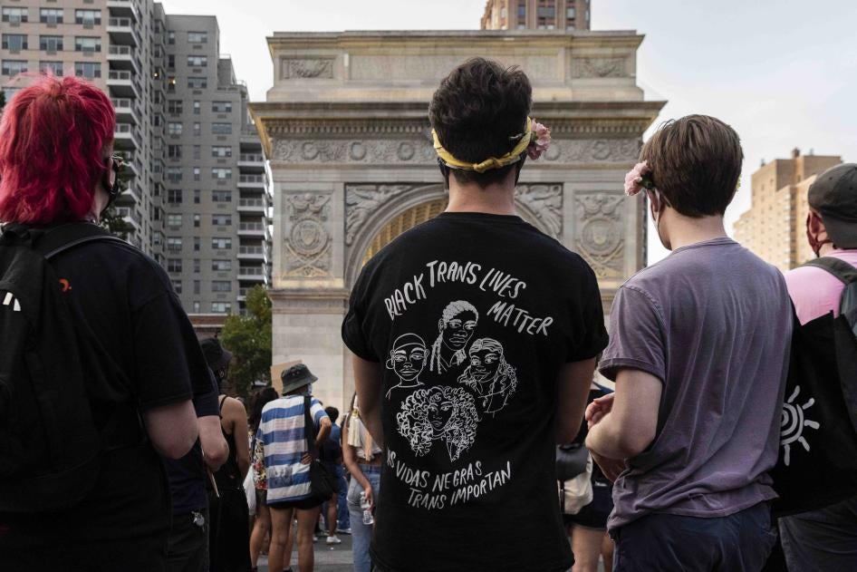 A person wearing a shirt that says "Black Trans Lives Matter (Las vidas negras trans importan)" at a rally