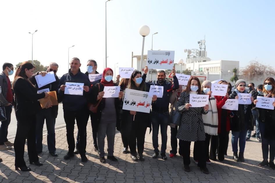 A group of people holding protest signs in Arabic