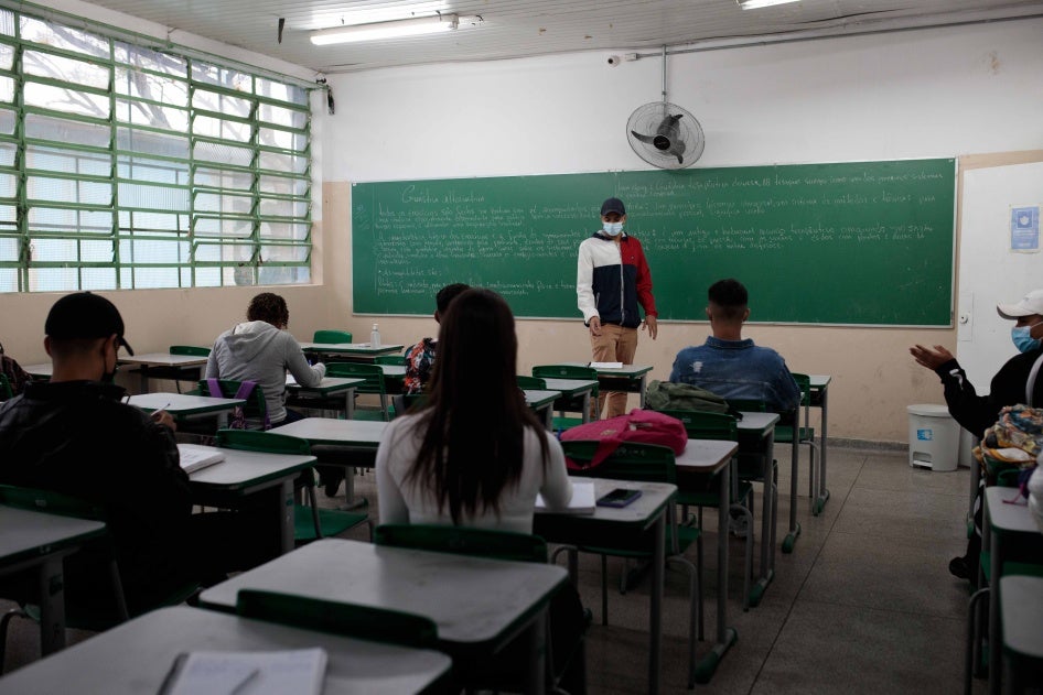 A teacher stands in front of a classroom of students