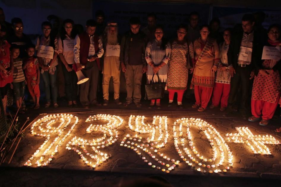 Nepalese human rights activists and relatives of disappeared persons, make a formation with lighted candles that reads 1350+ (referring to the number of victims) at an event to mark the International Day of the Disappeared in Kathmandu, Nepal, August 30, 2017.