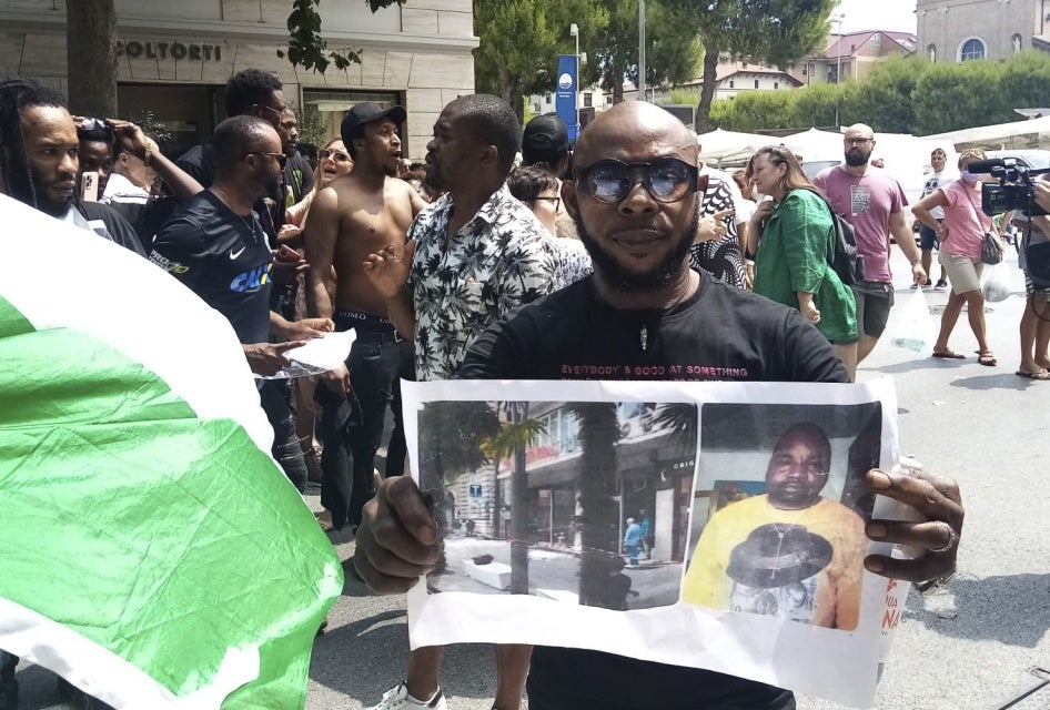 A man shows a picture of the victim Nigerian street vendor Alika Ogorchukwu