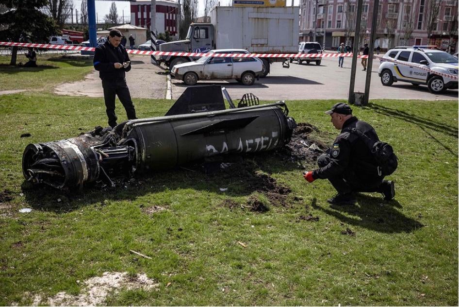 Ukrainian authorities inspect the rocket motor and guidance section of a Tochka-U missile next to the main building of the Kramatorsk train station in eastern Ukraine on April 8, 2022. The phrase “Payback for the children” is painted in Russian on the missile. 