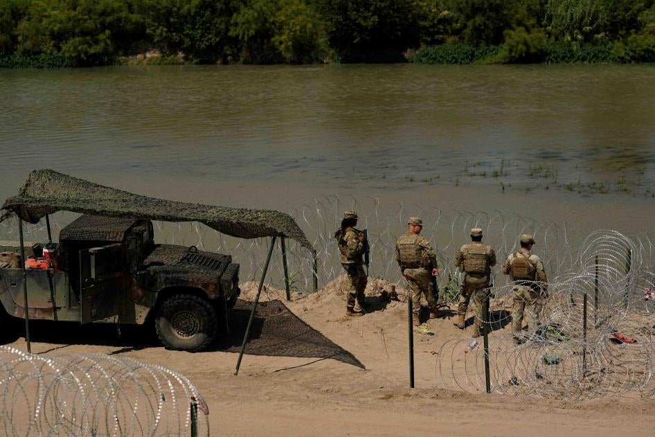 Des gardes observent les migrants qui tentent de traverser le Rio Grande du Mexique vers les États-Unis près d'Eagle Pass, au Texas, le 11 juillet 2023.