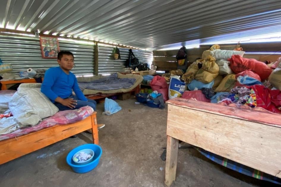 A boy sits on a bed in a room 
