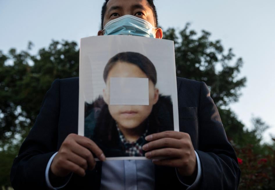 An activist holds a picture of an alleged young North Korean refugee during a demonstration calling on Chinese President Xi Jinping to allow safe passage to North Koreans detained in China, across the street from the Chinese embassy in Washington, DC, September 24, 2021. 