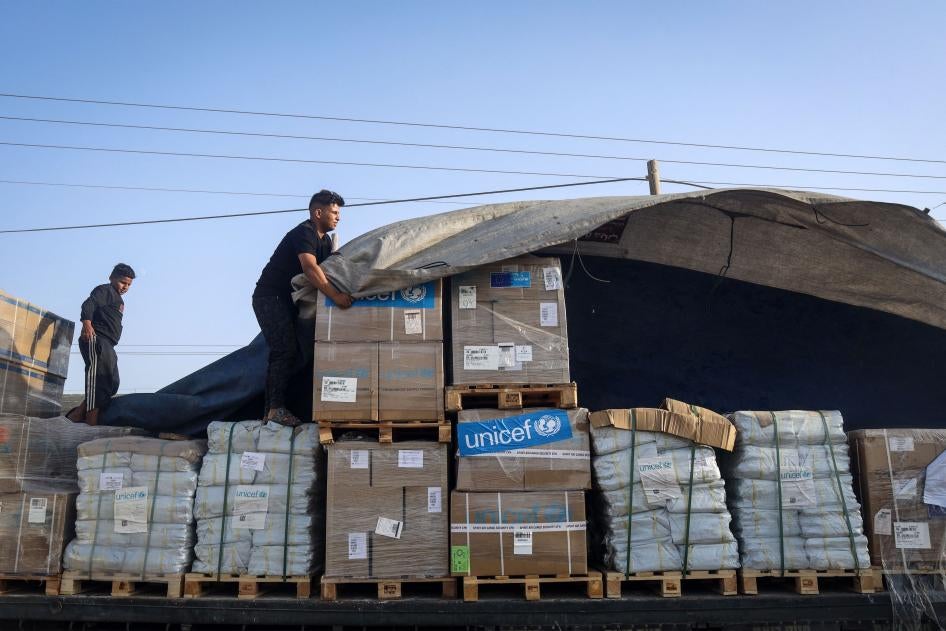 A man unloads humanitarian aid from a convoy of trucks entering the Gaza Strip from Egypt via the Rafah border crossing on October 21, 2023.