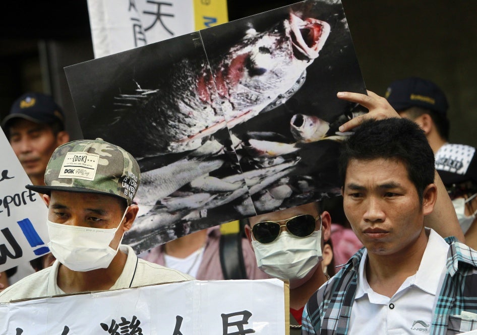 Vietnamese activists hold a photo of dead fish allegedly killed with toxic chemicals during a protest to urge Formosa Plastics Group to take responsibility for the cleanup in Vietnam, August 10, 2016, in Taipei, Taiwan.