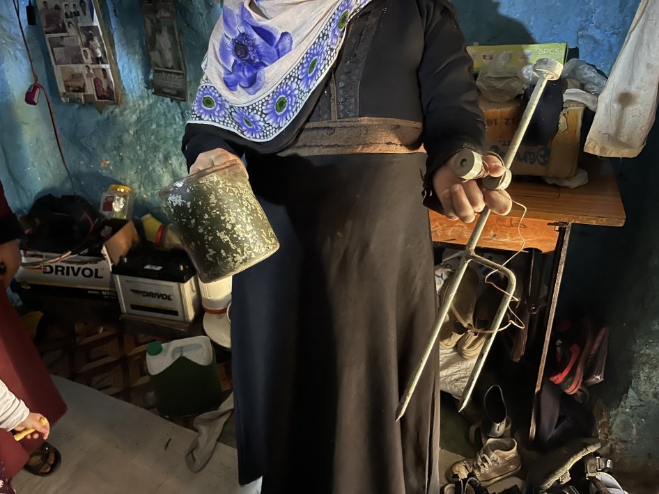 A woman holds up remnants of the landmine that killed her father, Al-Shaqb, Yemen, April 27, 2024.