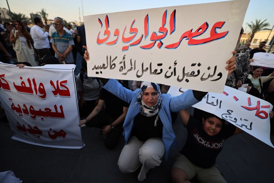 A woman holds a sign protesting women being deprived of their rights in marriage in Tahrir Square, Baghdad, Iraq, August 8, 2024.