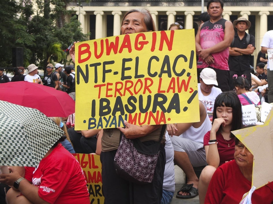 An activist holds a poster calling for abolishing the anti-communist task force