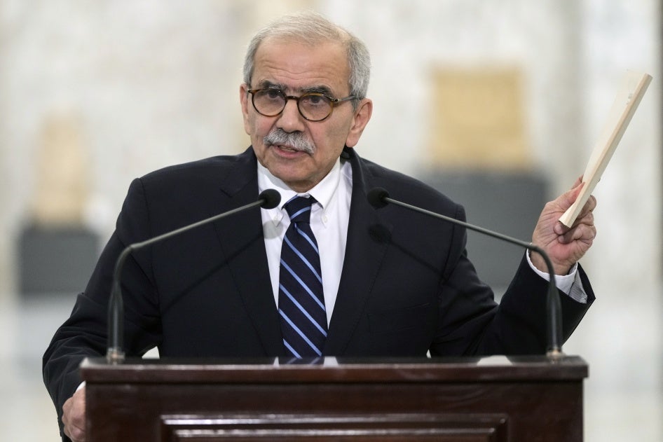 رئيس الوزراء اللبناني المُكلَّف نواف سلام يحمل نسخة من الدستور اللبناني أثناء تحدثه في القصر الرئاسي في بعبدا، لبنان، 14 يناير/كانون الثاني 2025. 