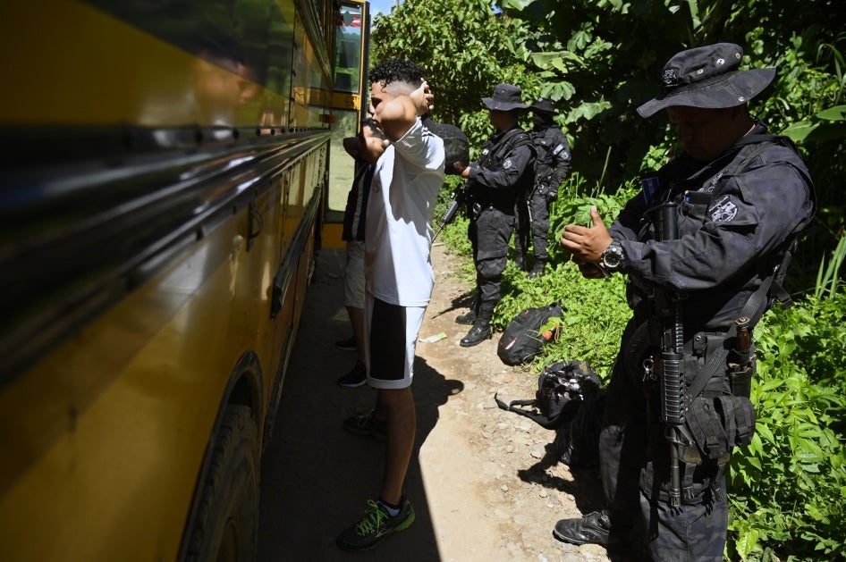 Die Polizei durchsucht die Passagiere vor einem Bus während des Ausnahmezustands in Santa Ana, El Salvador, am 30. Juni 2022.