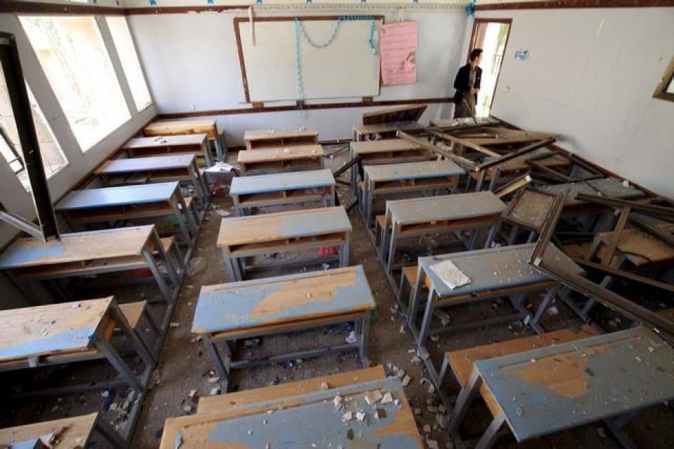 A man looks at a damaged classroom in a school after an air strike in Sanaa April 28, 2015. 