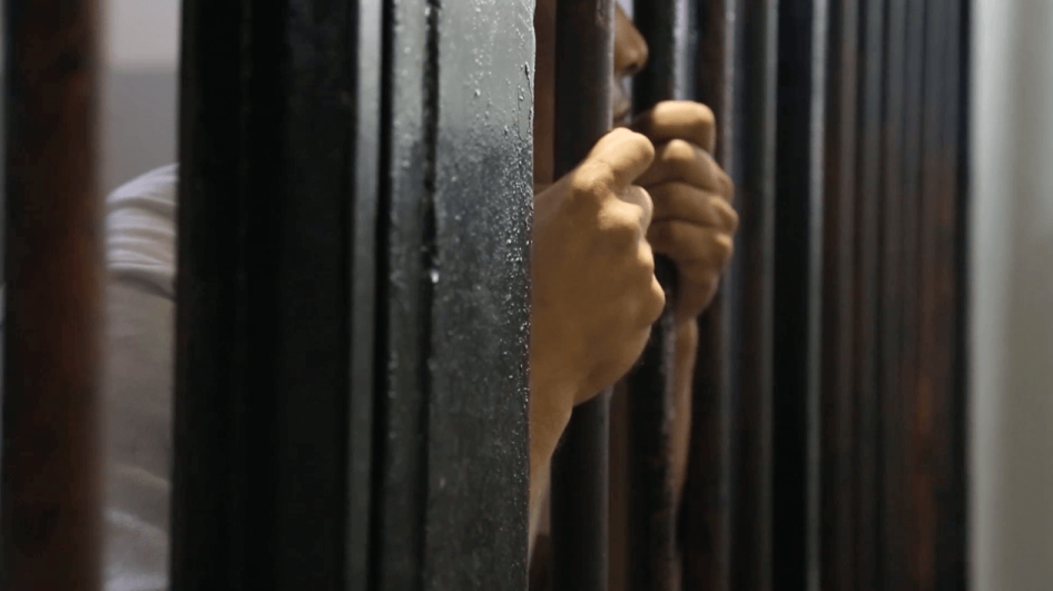 رجل يقف وراء القضبان في مركز احتجاز صفاقس، في تونس، في 26 سبتمبر/أيلول 2013.