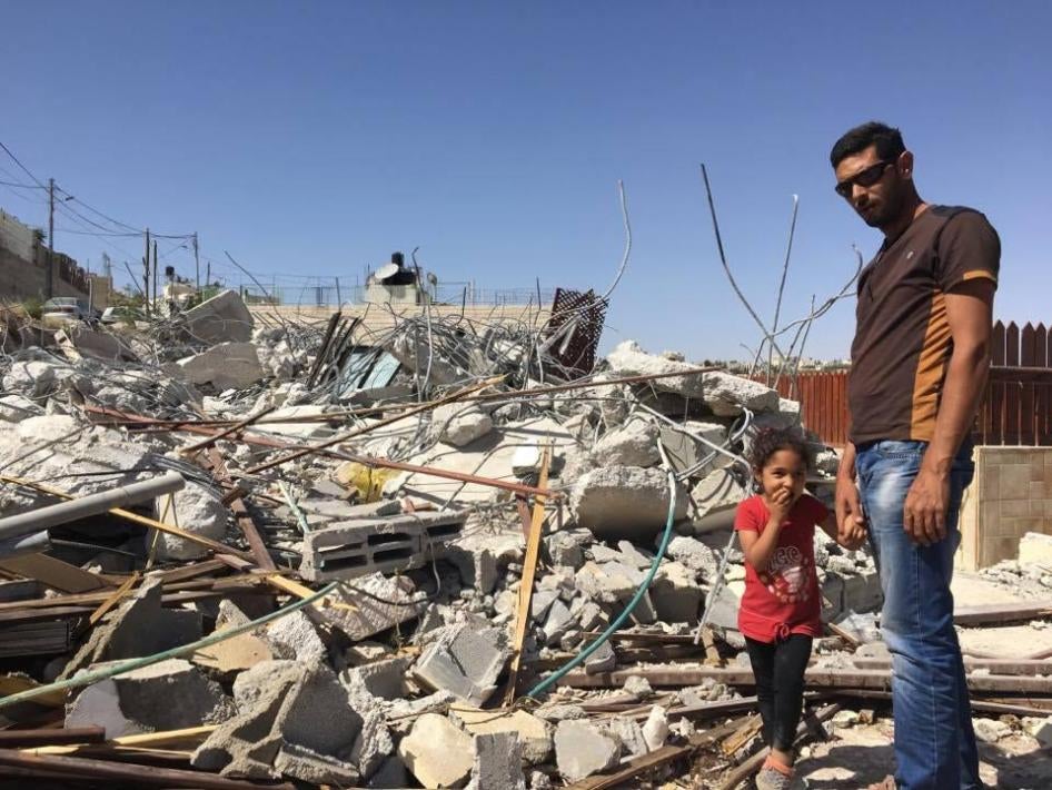 Ashraf Fawaqa and his daughter Sima, 4, stand next to the rubble of their East Jerusalem home on May 15; Israeli authorities demolished the house on May 4 because they lacked a permit.