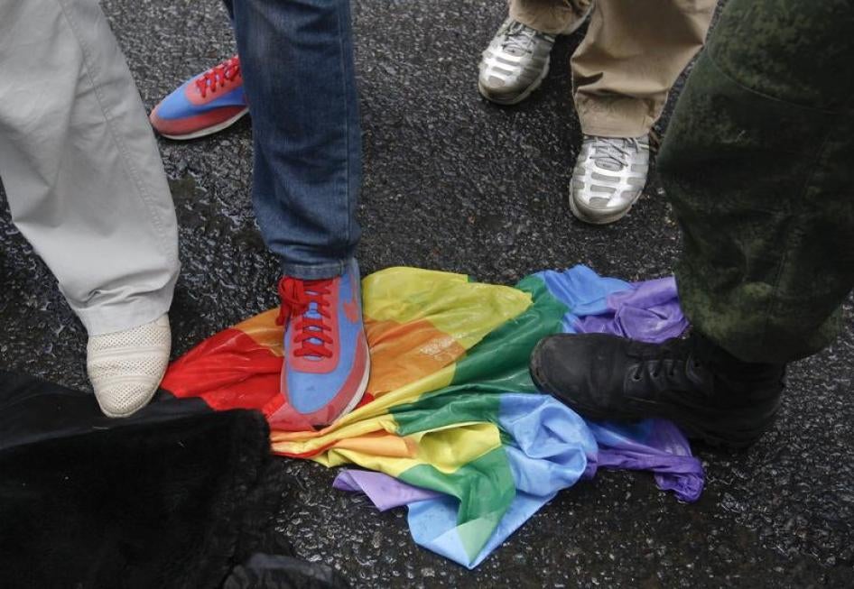 Anti-gay rights activists stand on a rainbow flag during a protest by gay rights activists demonstrating against a proposed new law termed by the State Duma, the lower house of Parliament, as "against advocating the rejection of traditional family values"
