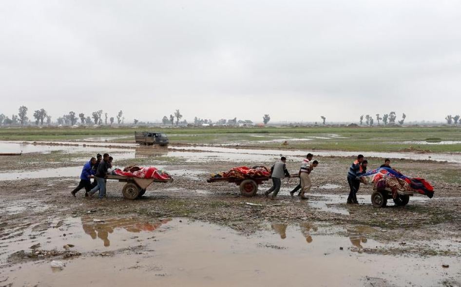 Relatives carry the bodies of civilians killed in an attack in New Mosul neighborhood of west Mosul on March 17, 2017. © 2017 Reuters