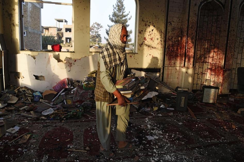 A man carries copies of the Quran inside the Imam Zaman Mosque in Kabul a day after the suicide attack during Friday evening prayers, October 21, 2017.