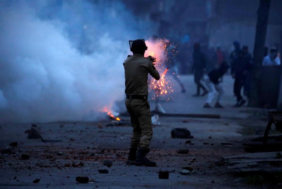 An Indian police officer fires a tear gas shell toward demonstrators, during a protest against the recent killings in Kashmir, in Srinagar, May 8, 2018.