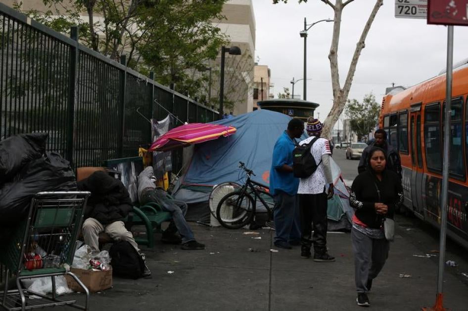People walk around the neighboring streets around the Fred Jordan Mission, in Los Angeles, California, U.S. May 12, 2018.