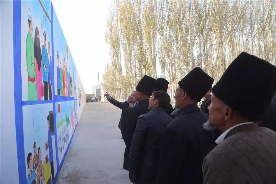 Officials bring villagers on tour outside a political education camp in Hotan.