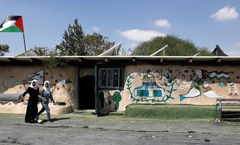 فتاتان فلسطينيتان تمشيان في باحة المدرسة الابتدائية في خان الأحمر في الضفة الغربية المحتلة، 6 سبتمبر/أيلول 2018. © 2018 أحمد غربلي/وكالة فرانس برس/غيتي إيمجز 