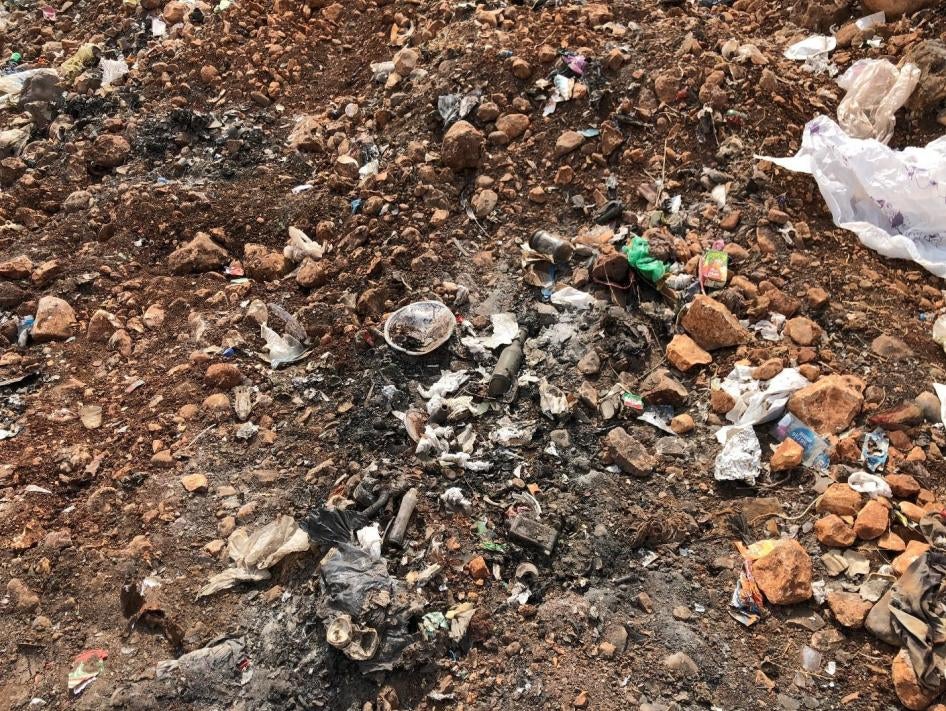 Signs of burning at the al-Qantara dump, including soot from recent burns and ash deposits. 