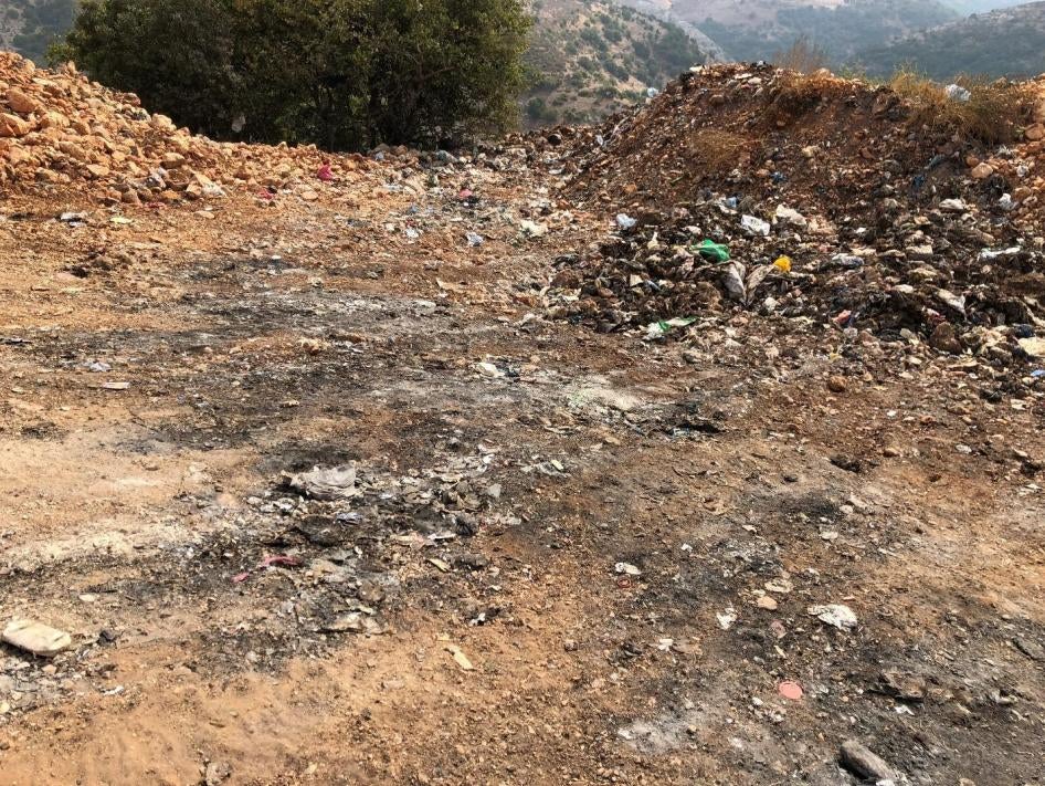 Signs of burning at the al-Qantara dump, including soot from recent burns and ash deposits. 