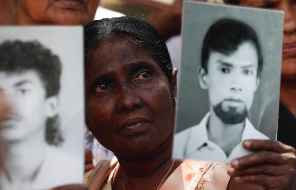 A woman holds a picture of a missing relative at a protest calling for investigations into enforced disappearances, Colombo, Sri Lanka, February 14, 2020.