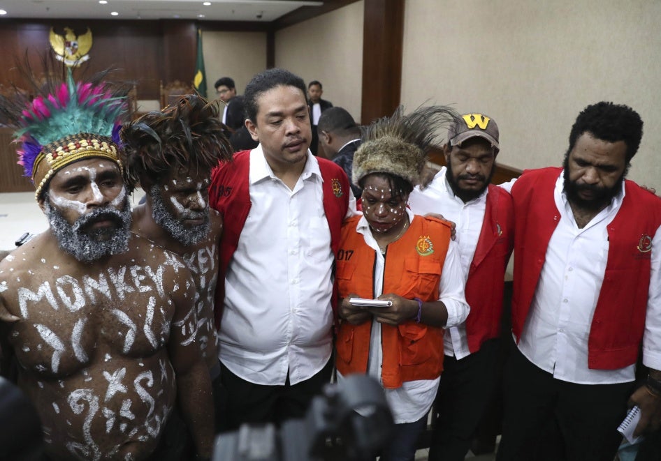 Des activistes papous accusés de trahison, photographiés dans un couloir du Tribunal de district central de Jakarta, en Indonésie, le 19 décembre 2019. Les deux hommes à gauche ont fait peindre le mot « monkey » (singe) en lettres blanches sur leur poitrines, afin de dénoncer le recours à ce terme en tant qu’insulte visant parfois les habitants de la province indonésienne de Papouasie. 