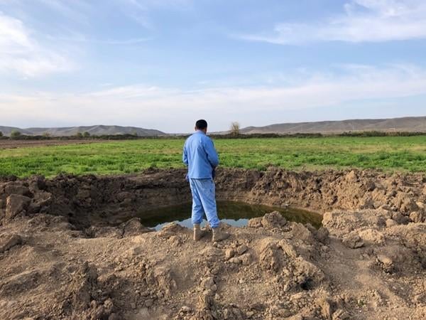 A member of the Azerbaijan National Agency for Mine Action looks at the crater of a Scud-B ballistic missile that hit on October 5, in a field near Babi village, Fizuli district.