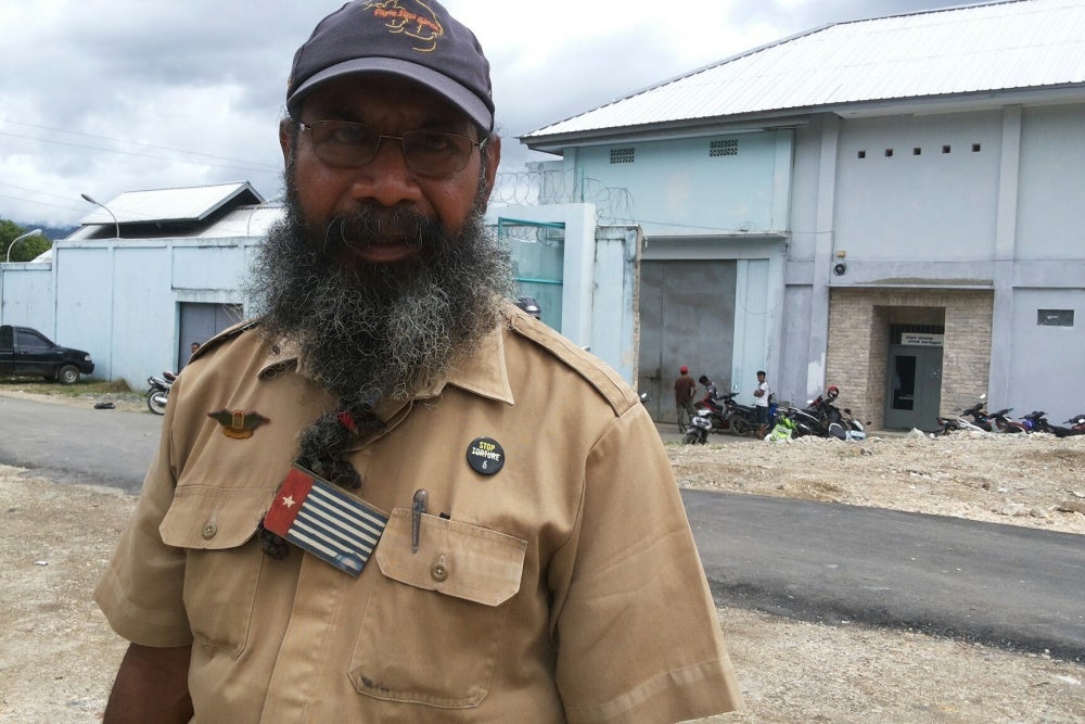 A man poses for a photo in front of a prison