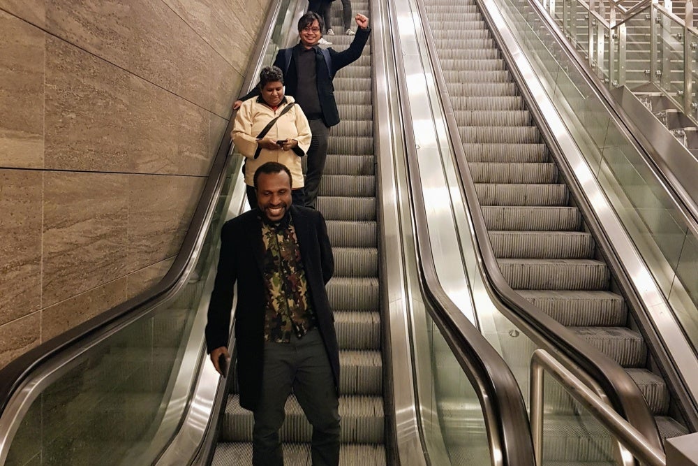 A group of people smiling on an escalator