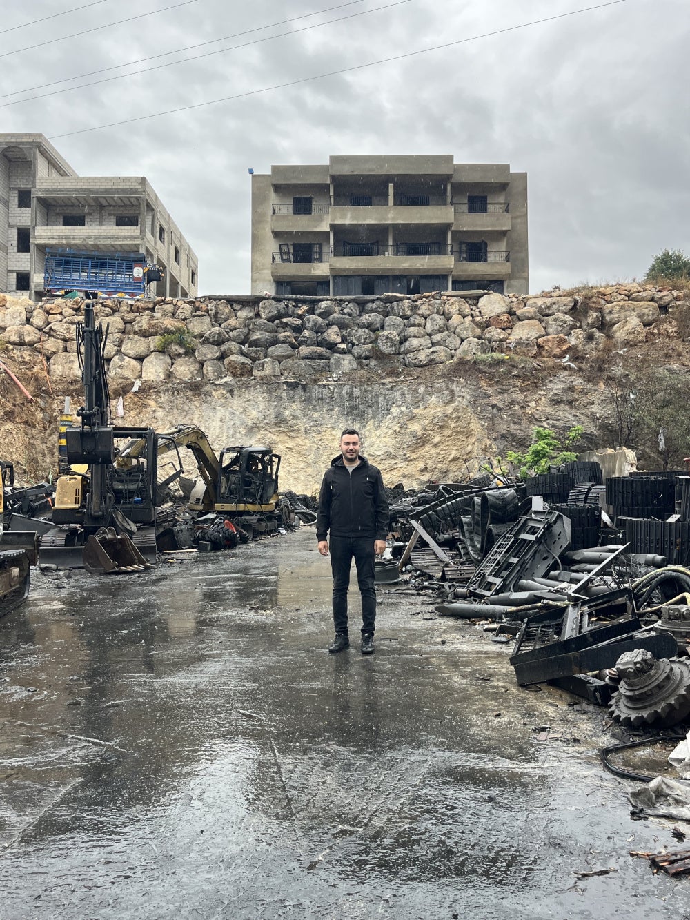 Imad Tabaja, the owner of one of the heavy-machinery showrooms targeted in Israeli airstrikes on October 11, 2025, stands in front of the wreckage at his site in Msayleh, southern Lebanon.