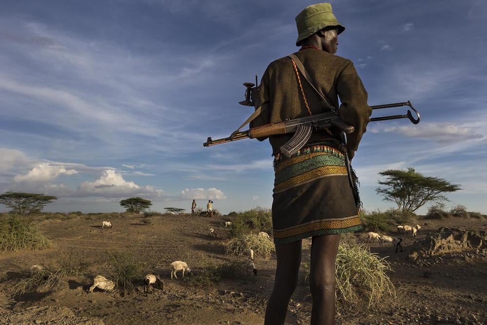 Des villageois déplacés portent des armes