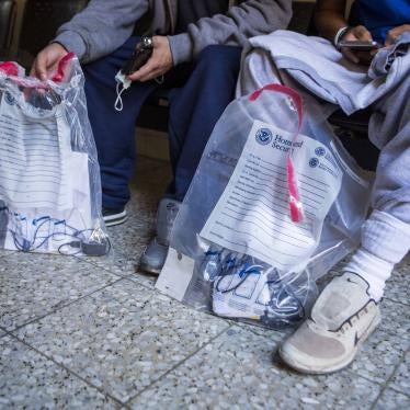 Aslyum seekers hold bags from the Department of Homeland Security