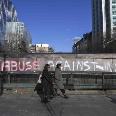 People walk past a graffiti reading ‘End abuse against women’ on Euston Road, in London, Friday March 6, 2020.