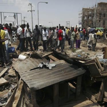 People gathered around the wreckage of a damaged road side tea shop following an explosion in Kaduna, Nigeria Monday, April 9, 2012. 