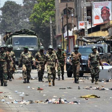 Uniformed soldiers march down a city street 