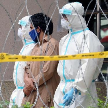 Police officers detain an immigrant from an apartment under enhanced lockdown in Kuala Lumpur, Malaysia, May 1, 2020. © 2020 REUTERS/Lim Huey Teng