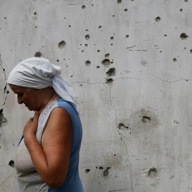 Local resident Katerina Izvekova, 77, shows her house damaged.
