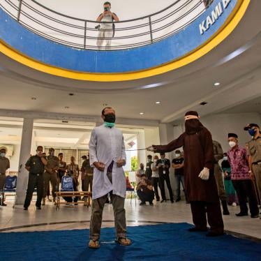 A Shariah law official uses a rattan cane to whip one of two men convicted of gay sex in Banda Aceh, Aceh province, Indonesia, January 28, 2021. 