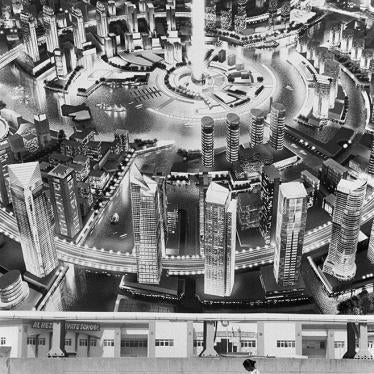 A foreign domestic worker with a child under a billboard in the United Arab Emirates.